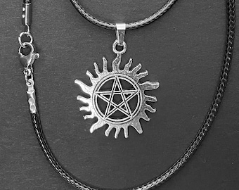 May include: A silver pendant necklace with a pentagram inside a sunburst design. The necklace is on a black braided cord.