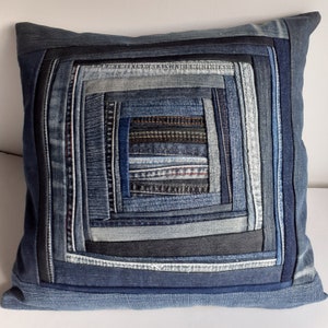 May include: A square denim pillow with a concentric square pattern made from different shades of blue denim.
