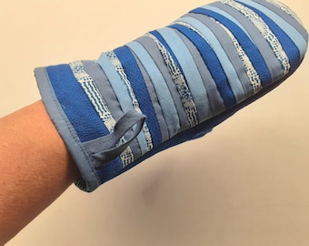 May include: Blue and white striped oven mitt with a loop handle. The mitt is made of fabric and is designed to protect hands from heat.