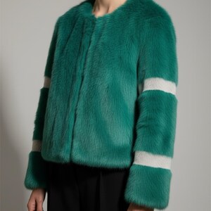 Op de afbeelding: Een felgroene imitatiebontjas met een ronde halslijn en lange mouwen. De mouwen hebben twee horizontale lichtgrijze banden. De jas wordt over een zwarte broek gedragen.