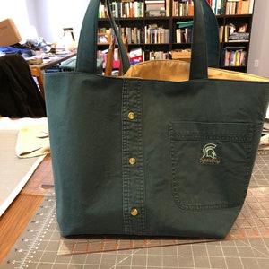 Small tote bag made from a men's button-down shirt. Bag depicted is from a green shirt. Interior of the bag is yellow.