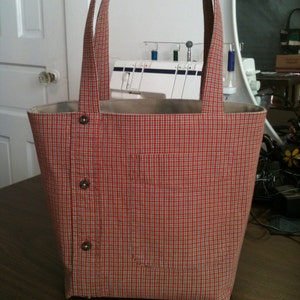 Small tote bag made from a men's button-down shirt. Bag depicted is from a burnt orange and tan plaid shirt