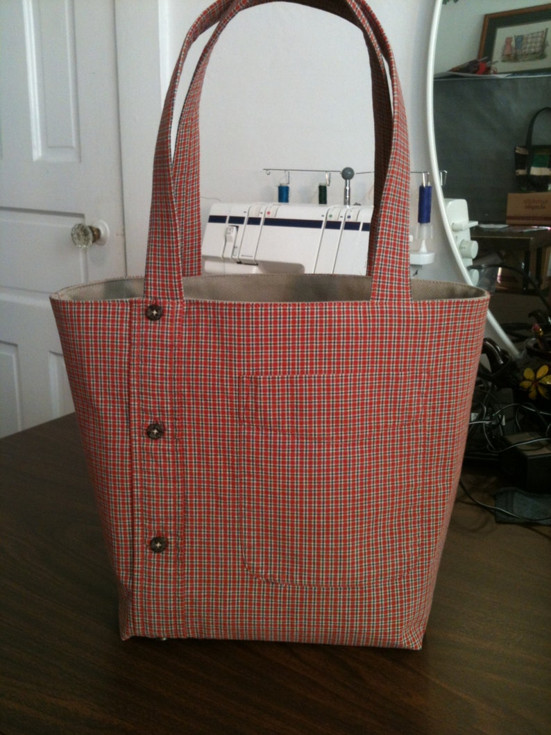 Small tote bag made from a men's button-down shirt. Bag depicted is from a burnt orange and tan plaid shirt