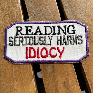Reading Harms Idiocy Embroidered Patch: Purple Satin Stitch