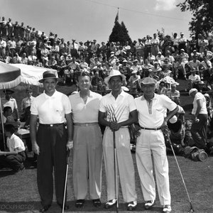 Puede incluir: Cuatro hombres con camisas blancas y sombreros est&aacute;n de pie en un campo de golf, sosteniendo palos de golf. Est&aacute;n rodeados por una gran multitud de espectadores.
