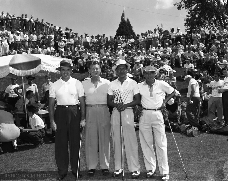 Puede incluir: Cuatro hombres con camisas blancas y sombreros est&aacute;n de pie en un campo de golf, sosteniendo palos de golf. Est&aacute;n rodeados por una gran multitud de espectadores.