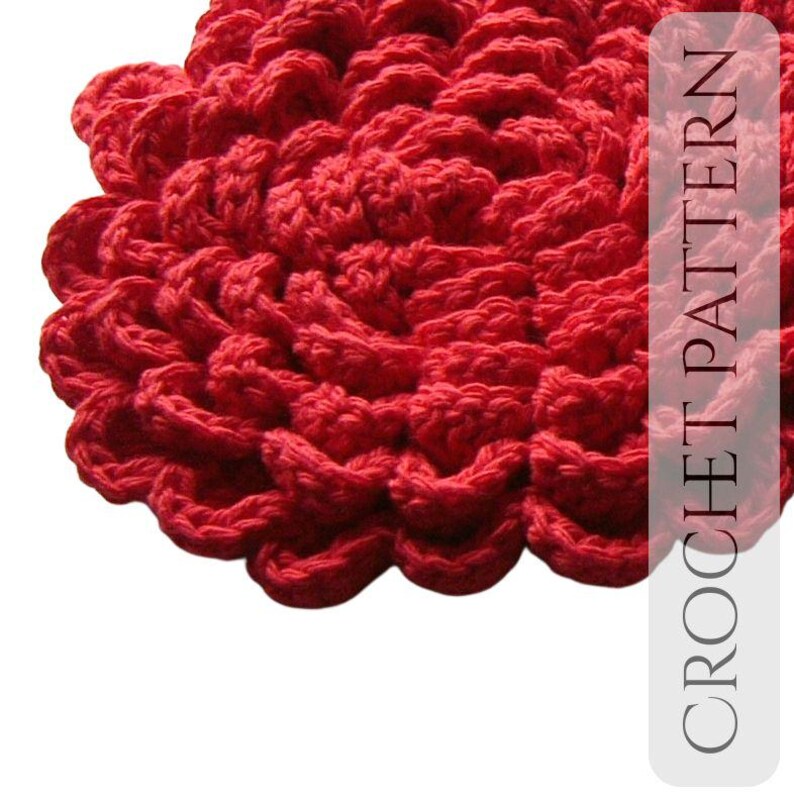 May include: Close-up of a vibrant red crocheted item with a textured, layered design. The item's surface is made up of repeating, rounded shapes. The text "CROCHET PATTERN" is visible on the right side of the image.