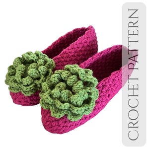 May include: A pair of handmade, magenta crochet slippers with a green floral embellishment on the toe. The slippers are made with a textured stitch and feature the text "CROCHET PATTERN" in a vertical column.