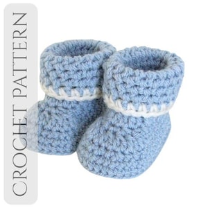 Peut inclure: Une paire de chaussons de bébé en crochet bleu clair avec une bordure blanche. Les chaussons sont faits d'un fil doux et texturé et ont un revers. Le motif de crochet est visible, et les chaussons semblent faits à la main.