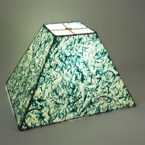 May include: A green and white pyramid-shaped lampshade with a textured paper surface.