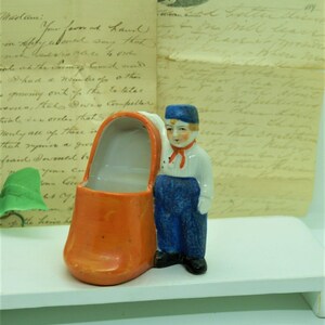 Dutch Boy Standing Next to Large Orange Clog/ Shoe Planter