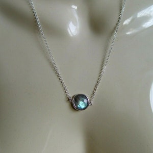 Może przedstawiać: Srebrny naszyjnik z łańcuszkiem i okrągłym, tęczowym niebieskim kamieniem szlachetnym.