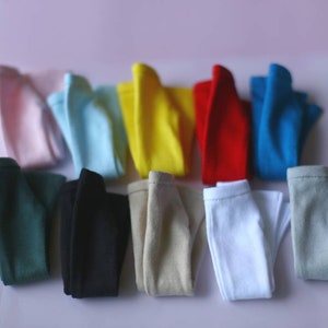 K&ouml;nnte beinhalten: Ein Set aus zehn gefalteten T-Shirts in verschiedenen Farben, darunter rosa, blau, gelb, rot, gr&uuml;n, schwarz, beige, wei&szlig; und grau.