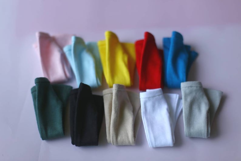 K&ouml;nnte beinhalten: Ein Set aus zehn gefalteten T-Shirts in verschiedenen Farben, darunter rosa, blau, gelb, rot, gr&uuml;n, schwarz, beige, wei&szlig; und grau.