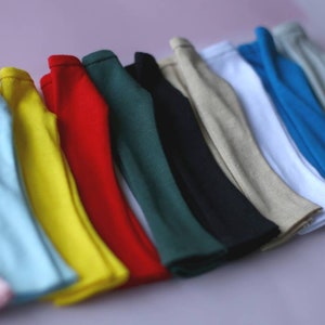 K&ouml;nnte beinhalten: Ein Satz von 12 Stoffstreifen in verschiedenen Farben, darunter rosa, blau, gelb, rot, gr&uuml;n und beige. Die Streifen sind in einer Reihe angeordnet, wobei der rosa Streifen unten und der beige Streifen oben liegt.