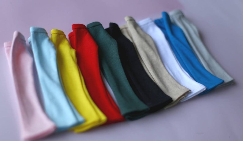 K&ouml;nnte beinhalten: Ein Satz von 12 Stoffstreifen in verschiedenen Farben, darunter rosa, blau, gelb, rot, gr&uuml;n und beige. Die Streifen sind in einer Reihe angeordnet, wobei der rosa Streifen unten und der beige Streifen oben liegt.