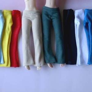 K&ouml;nnte beinhalten: Ein Set mit zehn Paaren Puppenhosen in verschiedenen Farben, darunter rosa, hellblau, gelb, rot, beige, gr&uuml;n, schwarz, wei&szlig;, blau und grau.