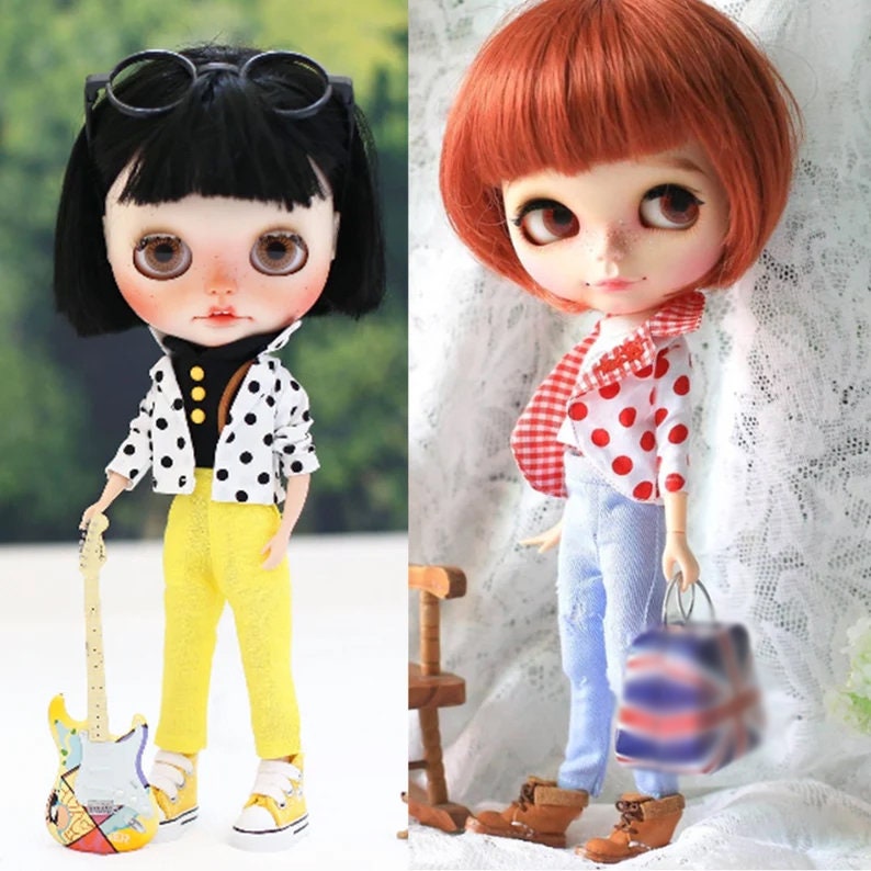 May include: Two dolls with black and red polka dot shirts and jeans. One doll is holding a guitar and the other is holding a small bag.