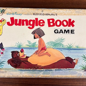 May include: Vintage "Jungle Book" board game box featuring illustrations of Baloo, Mowgli, Bagheera, and Kaa. The title "Jungle Book GAME" is in red letters. The box has a worn, aged appearance.
