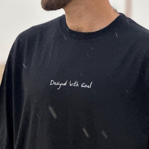 May include: A black t-shirt with the text "Designed with Soul" in white lettering.