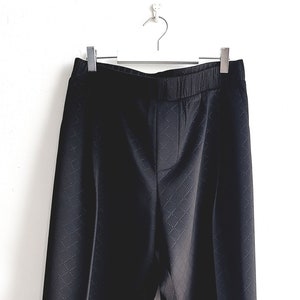 May include: Black pants with a diamond pattern. The pants have an elastic waistband and a straight leg.