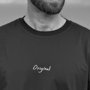 May include: A man wearing a black t-shirt with the word "Original" embroidered on the front. He is wearing black sunglasses and has a nose ring.
