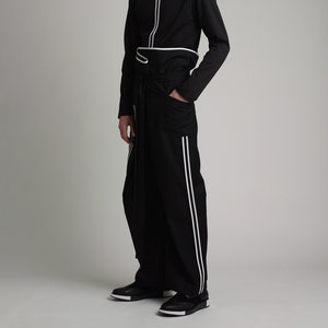 May include: A black long-sleeved shirt with white stripes and a matching black pair of pants with white stripes down the sides.