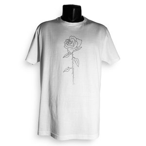 May include: White t-shirt with a black line drawing of a rose on the front.