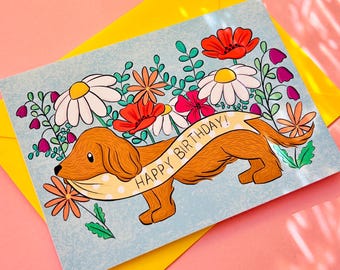 Tarjeta de cumpleaños de perro salchicha: Tarjeta artística con diseño de perro salchicha con flores silvestres