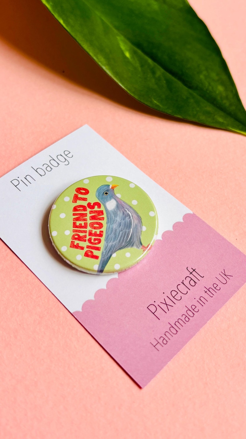 cute pigeon hand drawn badge on a green and white polka dot background that reads friend to pigeons
