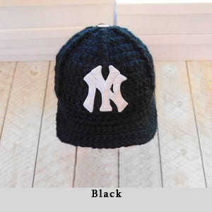 Puede incluir: Gorra de b&eacute;isbol negra con el logotipo "NY" blanco. La gorra est&aacute; hecha de un material texturizado y tiene una visera curvada. La palabra "Black" se muestra en la parte inferior de la imagen.