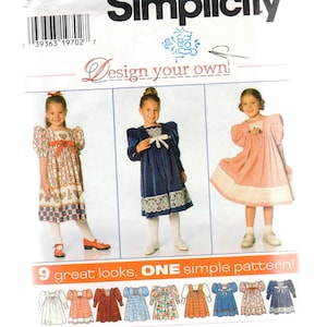 Op de afbeelding: Een Simplicity naaipatroon envelop, nummer 7411, maat BB 5, 6, 6X. De verpakking bevat de tekst Design your own en 9 great looks, ONE simple pattern! Het toont drie kinderen in verschillende jurkstijlen en negen illustraties.