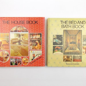 May include: Two hardcover books by Terence Conran. The left book is red with a brick pattern and titled THE HOUSE BOOK. The right book is yellow with a subtle floral pattern and titled THE BED AND BATH BOOK. Both feature multiple interior photos.