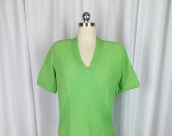 May include: A lime green two-piece dress with a short-sleeved top and a skirt. The top has a V-neck and a criss-cross design in the front.