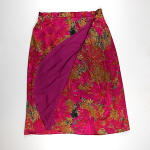 Pu&ograve; includere: Una gonna a portafoglio con stampa floreale rosa e marrone con fodera rosa unita. La gonna &egrave; lunga fino al ginocchio e ha un design semplice.