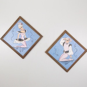 Può includere: Due illustrazioni incorniciate di ballerini. La prima illustrazione mostra una ballerina con un tutù rosa e scarpe nere. La seconda illustrazione mostra un ballerino maschile con un costume rosa e bianco. Entrambe le illustrazioni hanno uno sfondo blu con vortici bianchi.