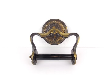 Soporte de papel higiénico de pared estilo mediados de siglo con acabado de latón envejecido, fabricado por Amerock.