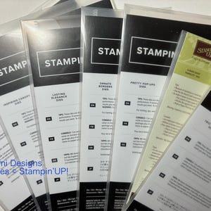May include: A collection of Stampin' Up! die sets in clear plastic packaging. The packaging features the word "STAMP" in a bold font, along with product names like "Inspiring Canopy Dies" and "Ornate Borders Dies."