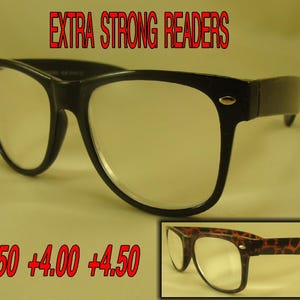 May include: Black plastic reading glasses with clear lenses. The glasses have a classic rectangular shape and are labeled "EXTRA STRONG READERS". The text +3.50 +4.00 +4.50 is also visible.