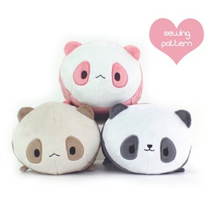 May include: Three plush panda toys, each with a different colored face. The top panda has a pink face, the middle panda has a brown face, and the bottom panda has a black face. All three pandas have black eyes and a black nose.
