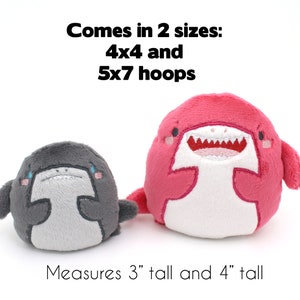 May include: Two plush shark toys, one pink and one gray, with embroidered details. The pink shark is 4 inches tall and the gray shark is 3 inches tall. The text "Comes in 2 sizes: 4x4 and 5x7 hoops" is above the toys. The text "Measures 3" tall and 4" tall" is below the toys.