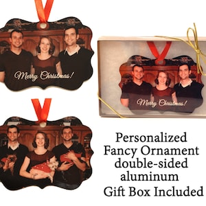 May include: Double-sided aluminum Christmas ornament with a family photo. The ornament is in a gold gift box. The ornament features the text "Merry Christmas!" on both sides.