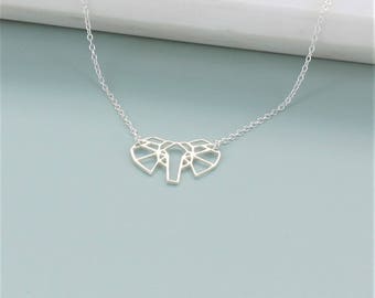 May include: A silver necklace with a geometric elephant pendant. The pendant is made of thin metal and has a delicate, origami-like design.