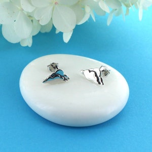 May include: A pair of silver cloud-shaped stud earrings. The earrings are small and delicate, and they are perfect for adding a touch of whimsy to any outfit.