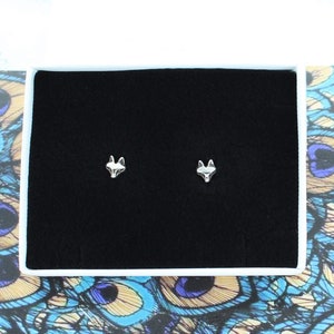May include: A pair of silver fox head stud earrings in a black velvet jewelry box.