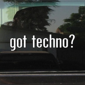 May include: Image of a car window with the text "got techno?" in white, bold letters. The background shows a blurred view of a house and trees, with reflections on the glass.