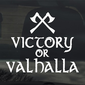 Könnte beinhalten: Weißer Vinyl-Aufkleber mit dem Text "VICTORY OR VALHALLA" in einer kräftigen, stilisierten Schriftart, mit gekreuzten Äxten darüber. Geeignet für die Anbringung auf einer Autoscheibe oder ähnlichen Oberflächen.