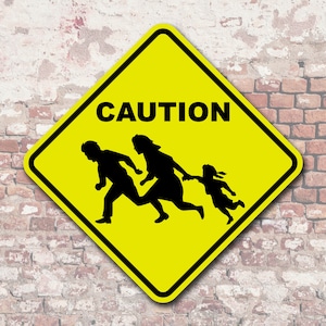 May include: A yellow diamond-shaped caution sign with black silhouettes of three people running. The sign reads "CAUTION" in black letters.