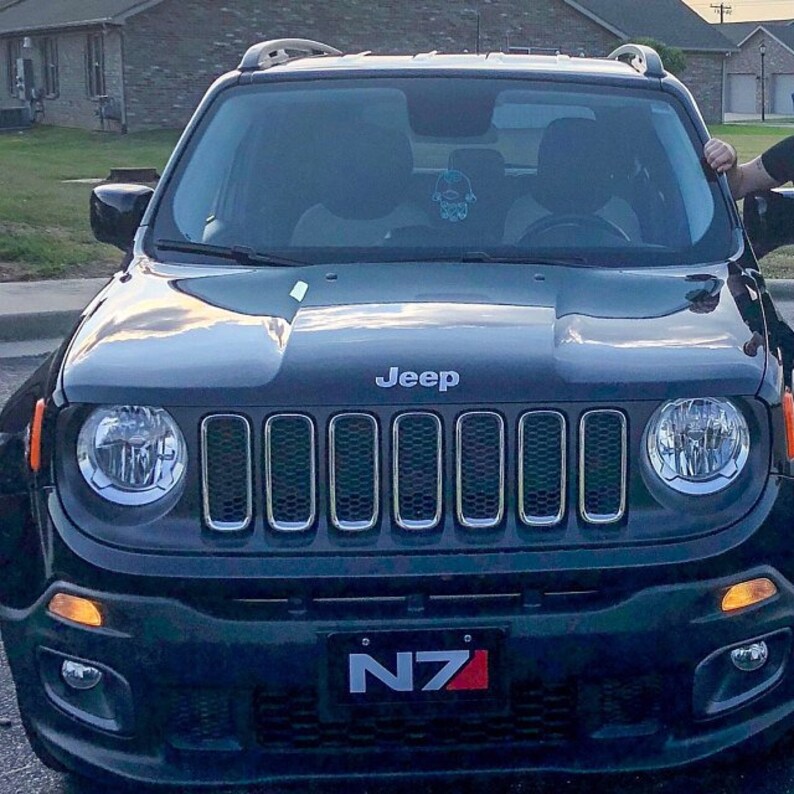 May include: A black Jeep Renegade with a silver grille and headlights. The car has a number plate that says "N7".