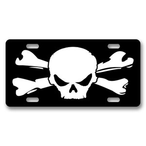 Puede incluir: Placa de matrícula negra con un diseño de calavera y huesos cruzados en blanco y negro.